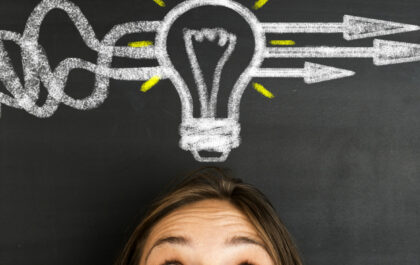 Person with lightbulb above her head that's drawn on a chalkboard