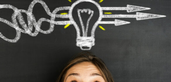 Person with lightbulb above her head that's drawn on a chalkboard