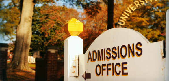 wooden-admissions-office-sign-at-college-campus-on-a-fall-day