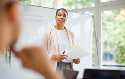 woman-at-front-of-whiteboard-in-classroom-leading