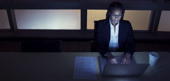 business-woman-in-dark-room-at-desk-on-computer-working