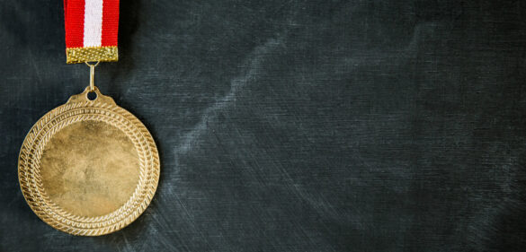 Success in education medal in front of blackboard